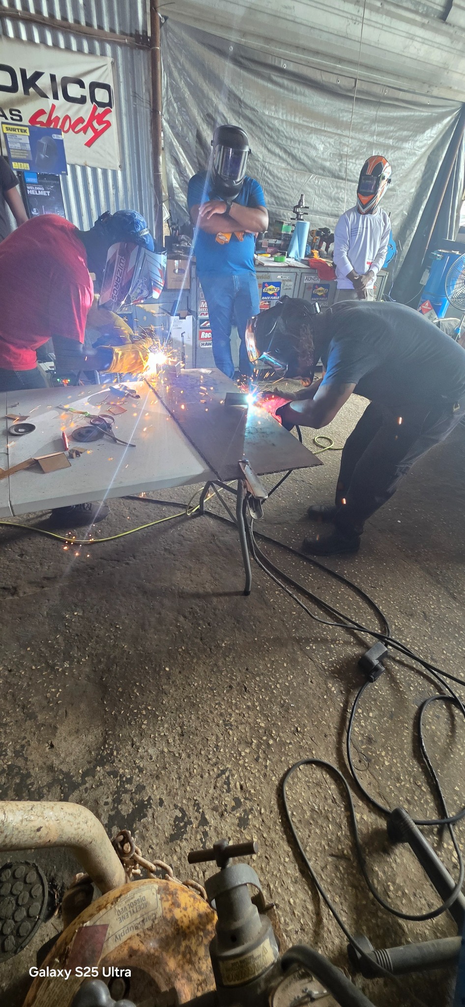 Students welding together during fabrication course